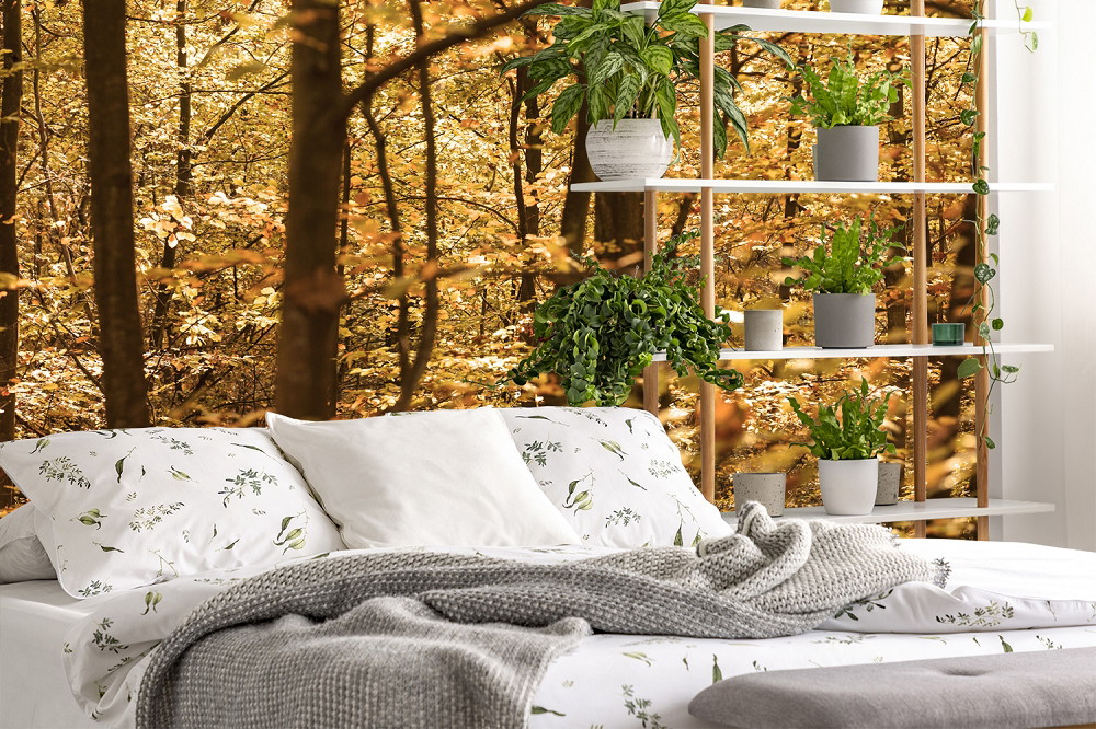 Fototapete - Schlafzimmer mit Bett vor einer Wand mit Waldmotiv und einem Regal mit grünen Pflanzen