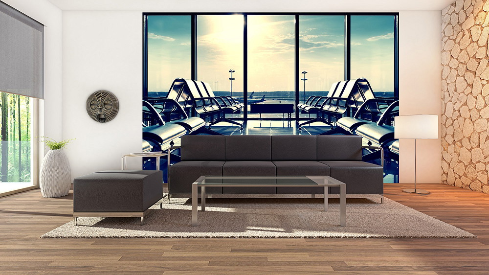 Fototapete - Wohnzimmer mit Sofa und Blick auf eine Flughafenlounge durch ein großes Fenster