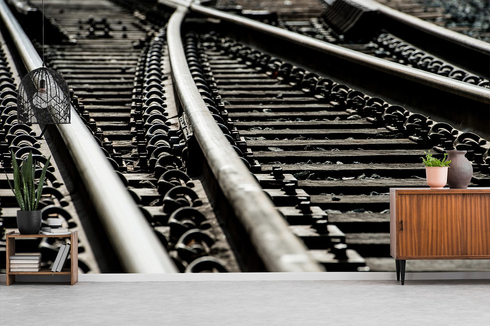 Wall mural - Detailed view of railway tracks with stylish interior design in the foreground