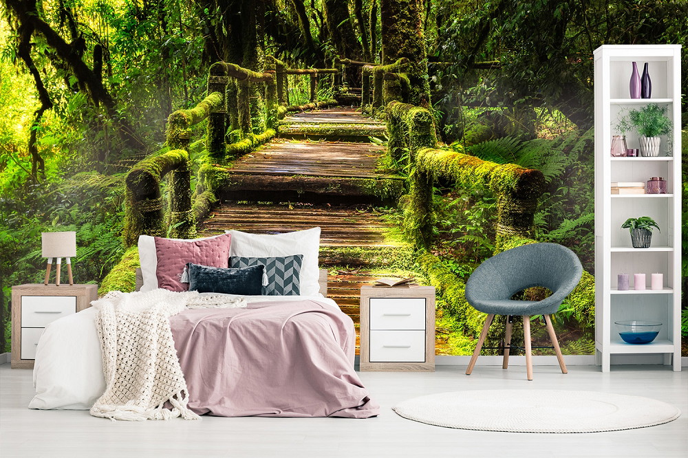 Fototapete - Gemütliches Schlafzimmer mit einer Fototapete, die einen moosbewachsenen Holzsteg in einem dichten, grünen Wald zeigt.
