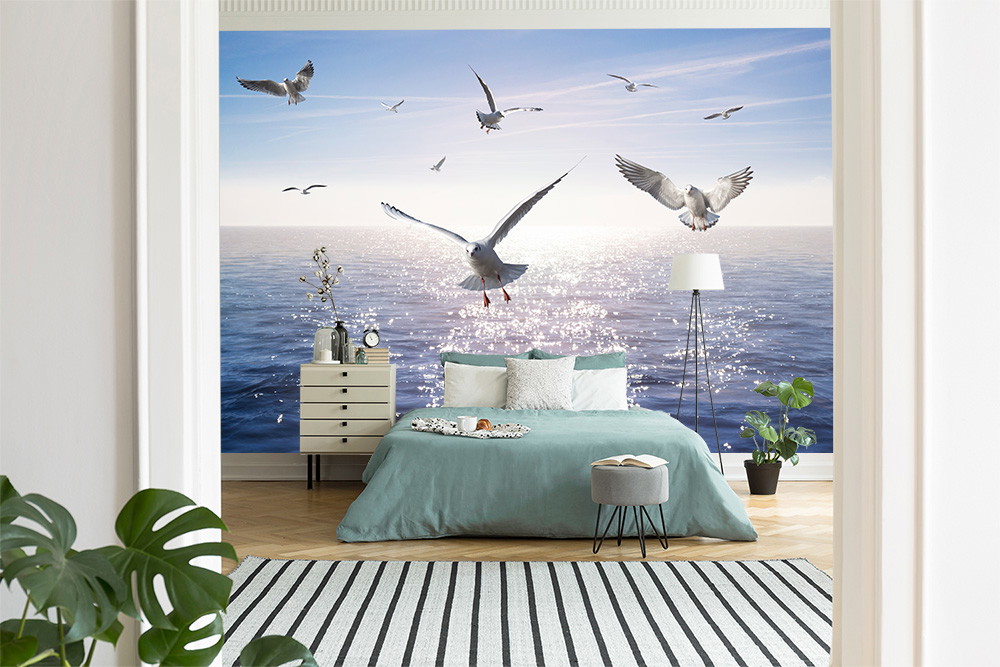Fototapete - Möwen fliegen über das Meer in einem stilvoll eingerichteten Schlafzimmer