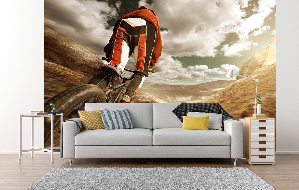 Fotobehang - Close-up van een mountainbiker die onder een dramatische hemel een steil bergpad afdaalt