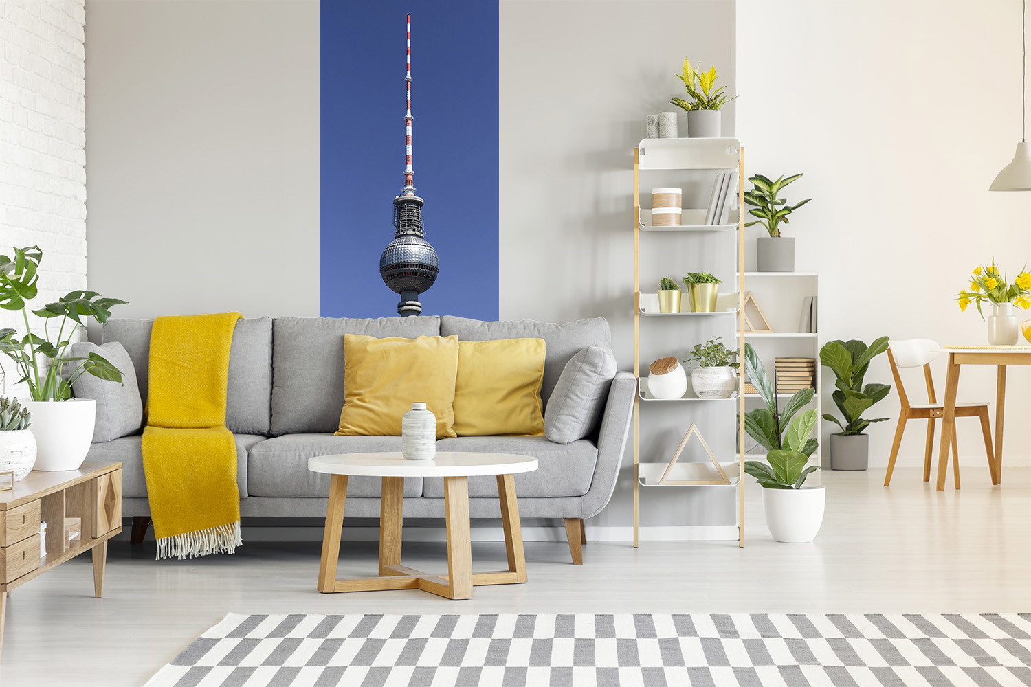 Papier peint photo - salon avec un canapé gris, des coussins jaunes et une image de la tour de télévision de Berlin sur le mur