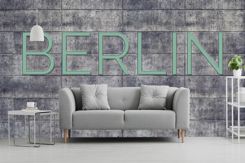 Fototapete - Grau gestaltetes Wohnzimmer mit Betonwand-Optik und prominentem 'Berlin'-Schriftzug im Hintergrund