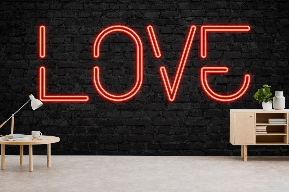 Papier peint photo - Inscription néon rouge 'LOVE' sur un mur de briques noires dans un salon décoré avec style
