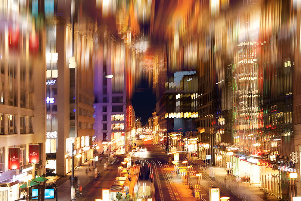 Wall mural - Blurred night shot of a lively city with glowing buildings and colourful lights