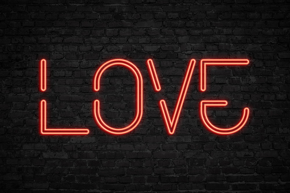 Wall mural - Red neon lettering 'LOVE' on black brick wall, bright and modern