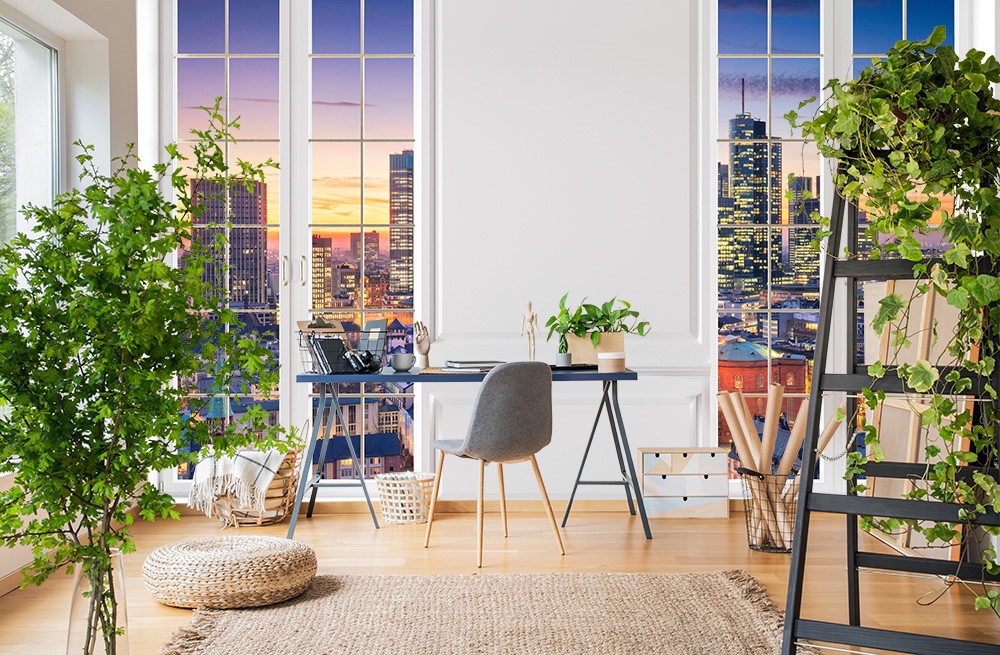 Fototapete - Büro mit moderner Stadtlandschaft als Fensterblick, umgeben von grünen Pflanzen und stilvoller Einrichtung