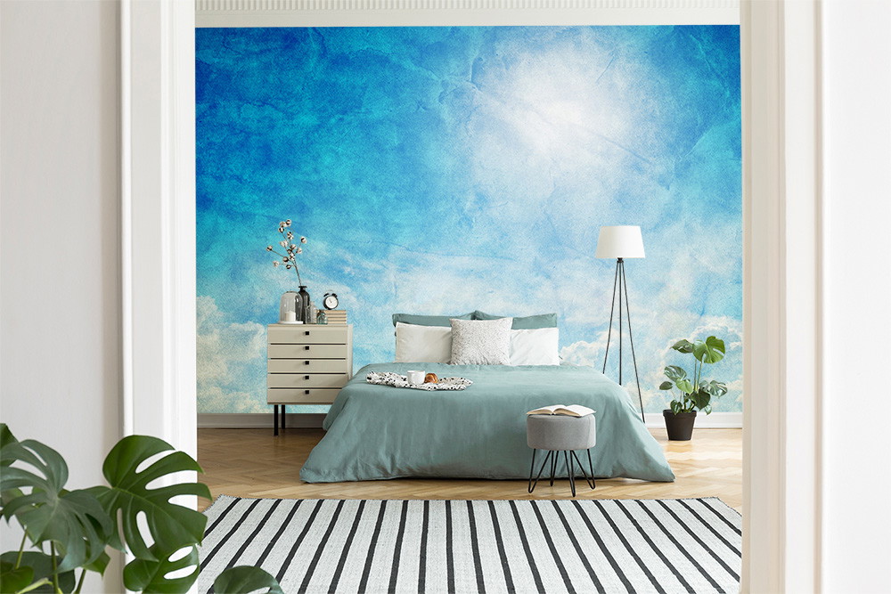 Wall mural - Blue and white sky wallpaper in a bedroom with a cosy bed and minimalist furnishings