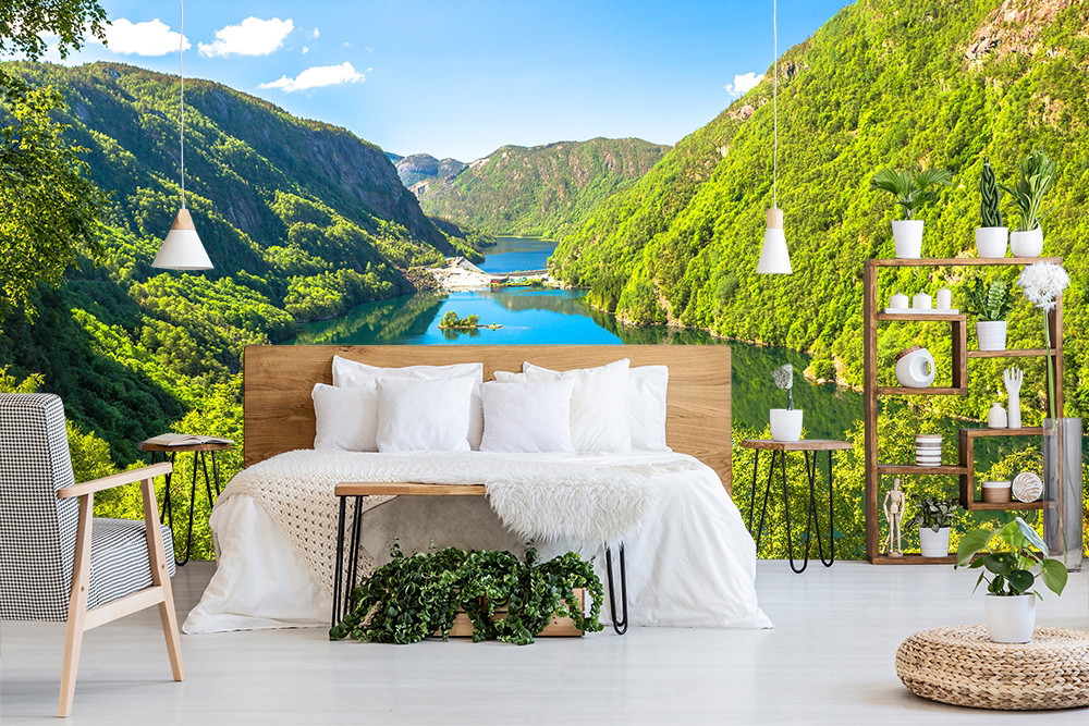 Fotomurale - Camera da letto con un impressionante sfondo naturale di un lago di montagna e colline verdi, circondata da mobili moderni.