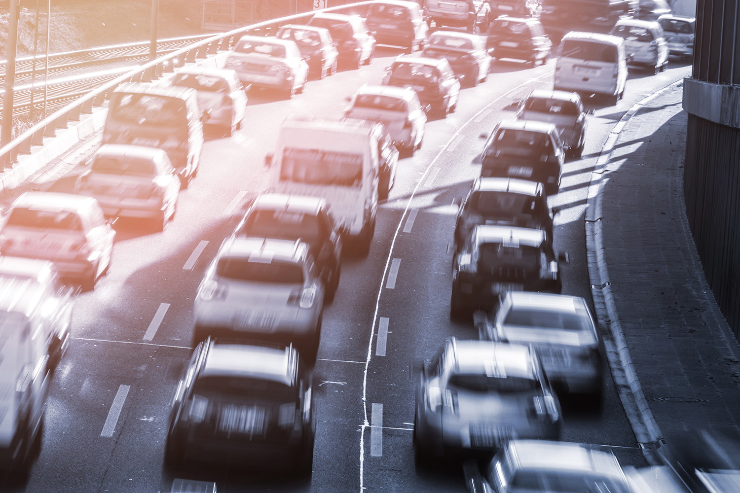 Fototapeta - Różne pojazdy w korku na autostradzie, oświetlone wieczornym słońcem