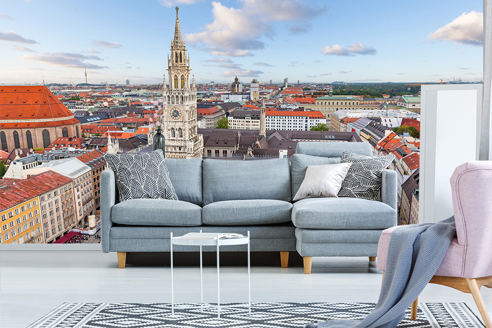 Wall mural - Grey sofa in front of a wall mural with a view of the old town of Munich and the town hall, which adorns the wall in the living room.