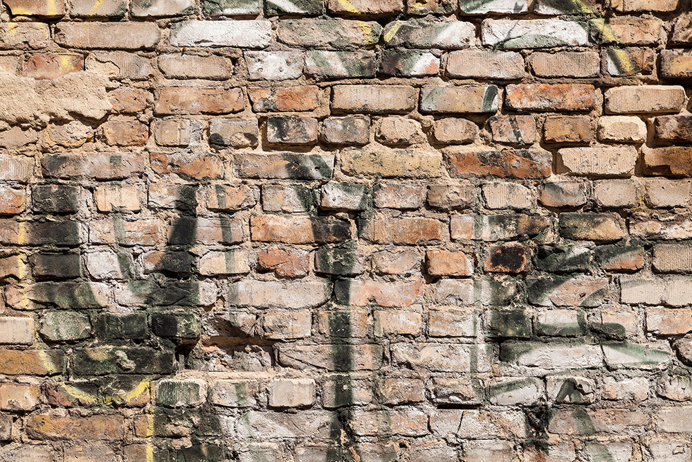 Wall mural - Close-up of an old brick wall with graffiti and natural colours