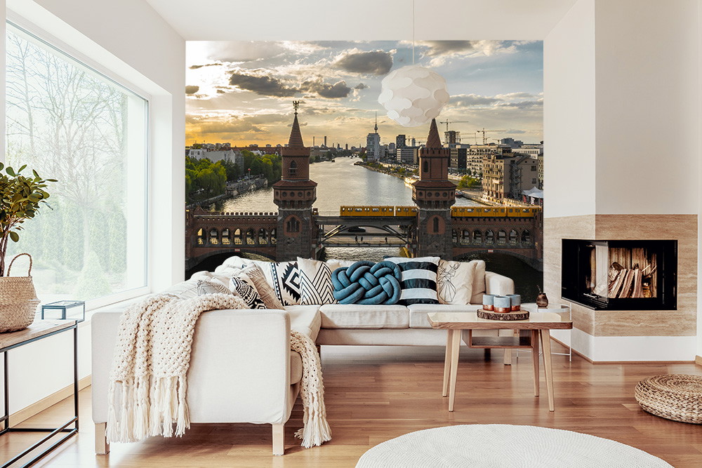 Fotobehang - Woonkamer met stedelijke skyline, brug en rivier bij zonsondergang
