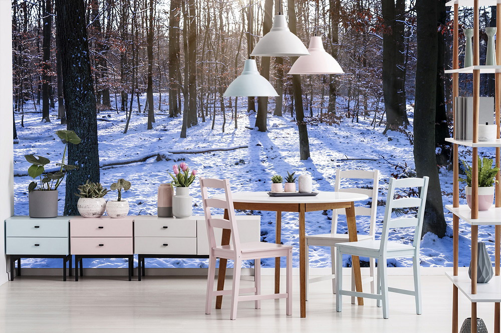 Fototapete - Ein Esszimmer mit moderner Einrichtung vor einer Fototapete mit schneebedecktem Wald bei Sonnenuntergang