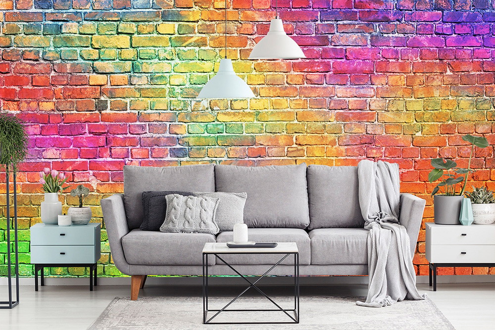Fototapete - Wohnzimmer mit grauem Sofa und bunter Ziegelwand, dekoriert mit Pflanzen und weißen Hängelampen