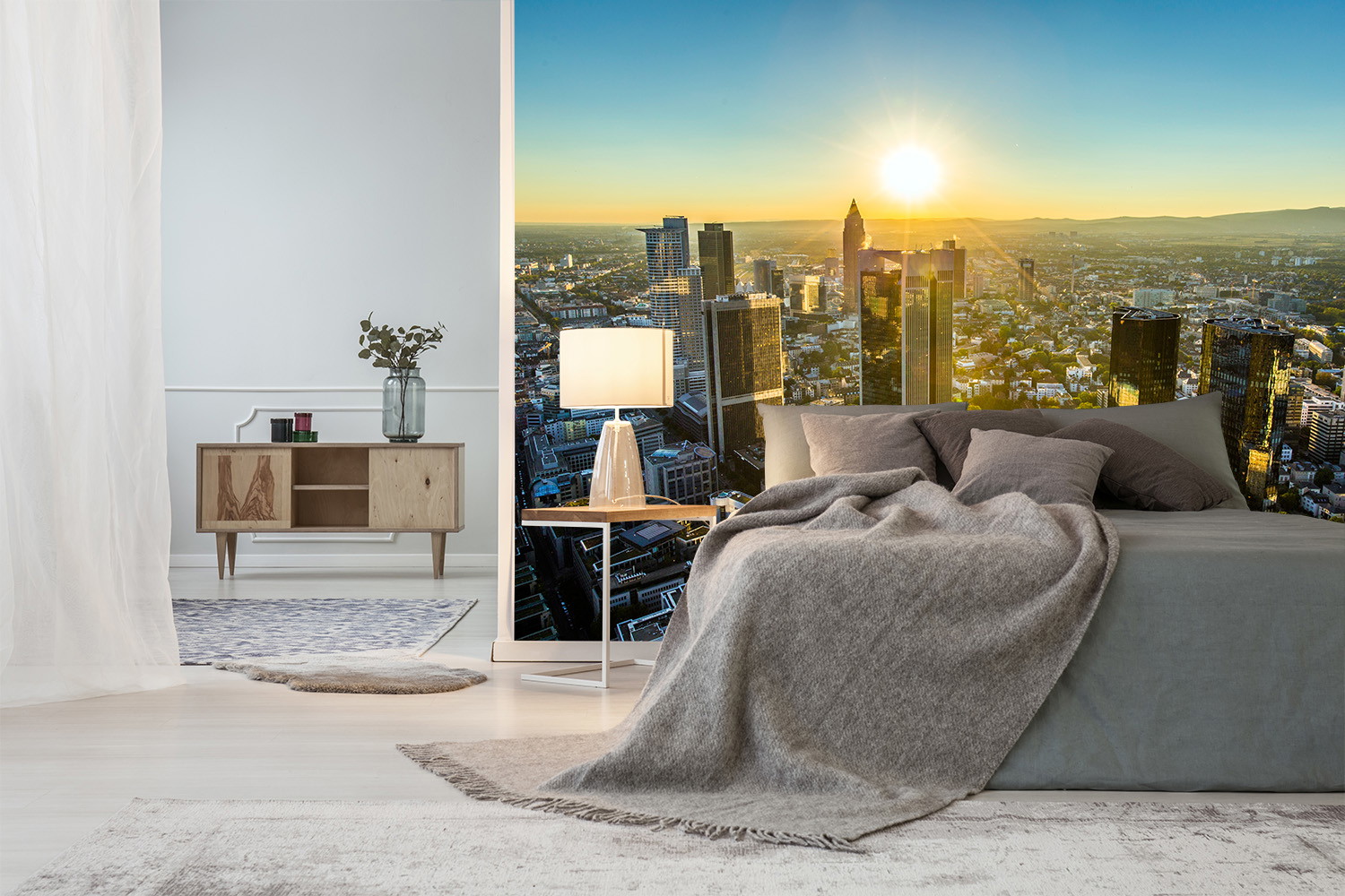 Fototapete - Schlafzimmer mit gemütlichem Bett und Panorama einer modernen Stadt bei Sonnenaufgang im Hintergrund
