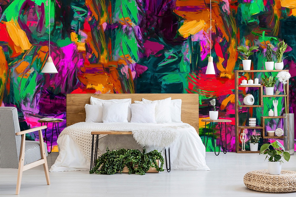 Wall mural - Abstract colourful wall mural in the bedroom shows rich colours such as green, pink and orange, complemented by minimalist furnishings with plants on shelves.