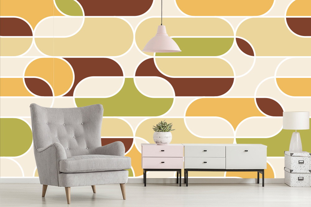 Papier peint photo - pièce avec un papier peint géométrique vintage jaune, vert et marron, un fauteuil gris et des meubles rétros