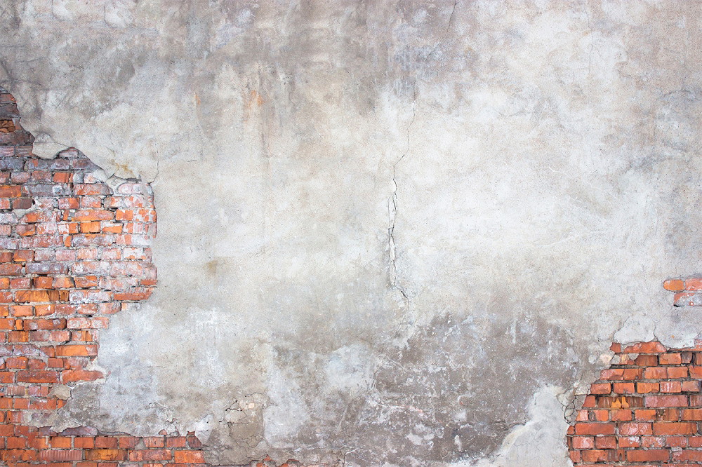 Wall mural - Old brick wall with crumbling plaster and visible cracks, ideal for rustic decoration