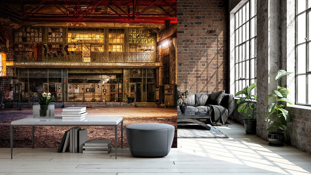 Fototapete - Impression eines industriellen Lofts mit einer Tapete, die eine alte Fabrikhalle zeigt, kombiniert mit modernem Wohnzimmerdesign, großen Fenstern und Pflanzen.