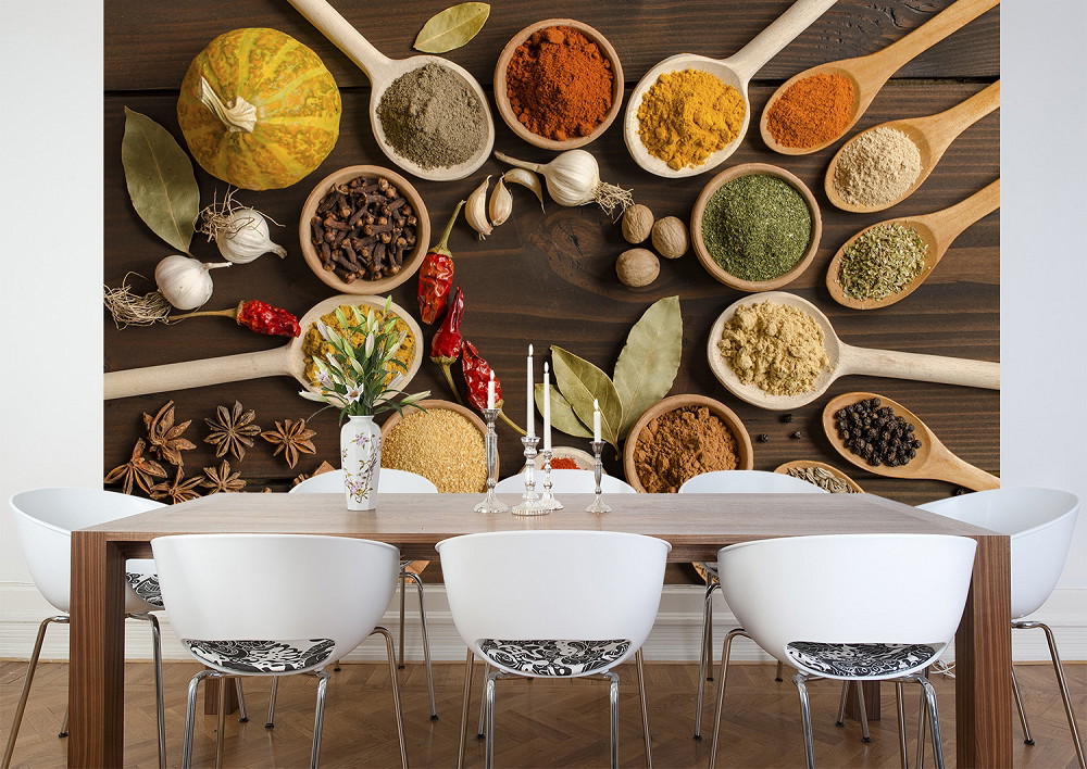 Wall mural - Various spices in wooden spoons next to a stylish table decoration in the dining room