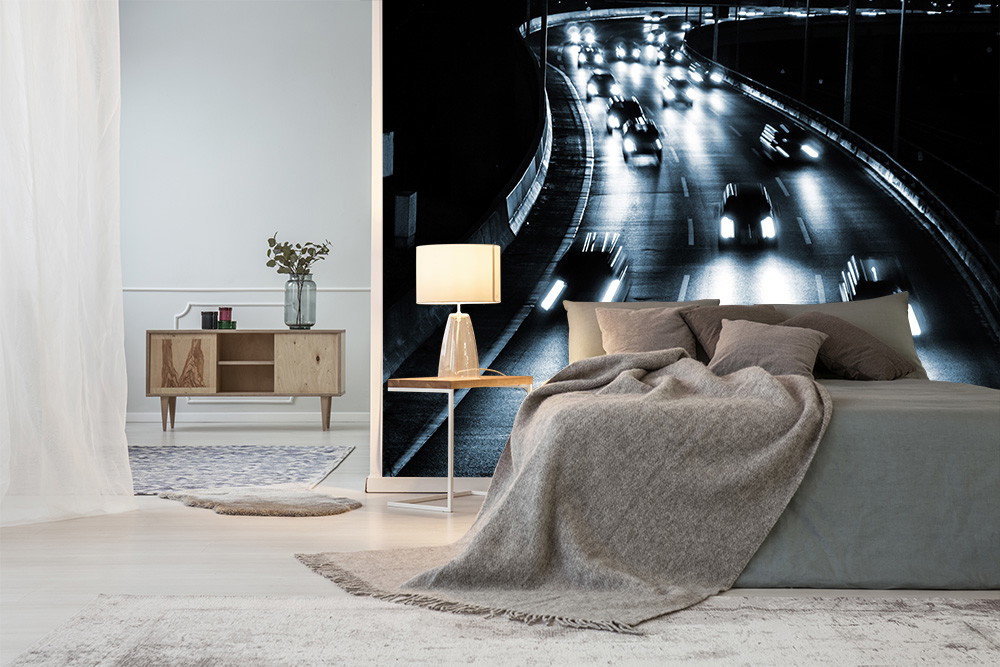 Fototapete - Autobahn bei Nacht mit leuchtenden Autoscheinwerfern neben einem stilvollen Schlafzimmer.