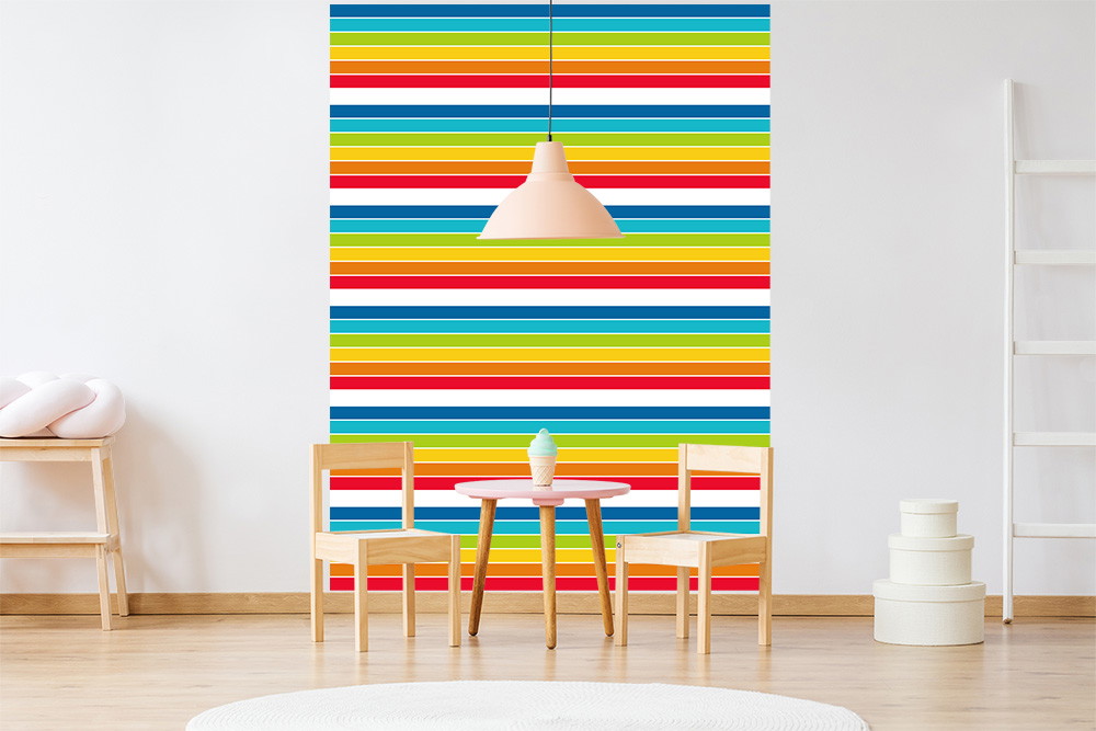 Muurschildering - Modern behang met kleurrijke strepen in een lichte kinderkamer met tafel, stoelen en verlichting
