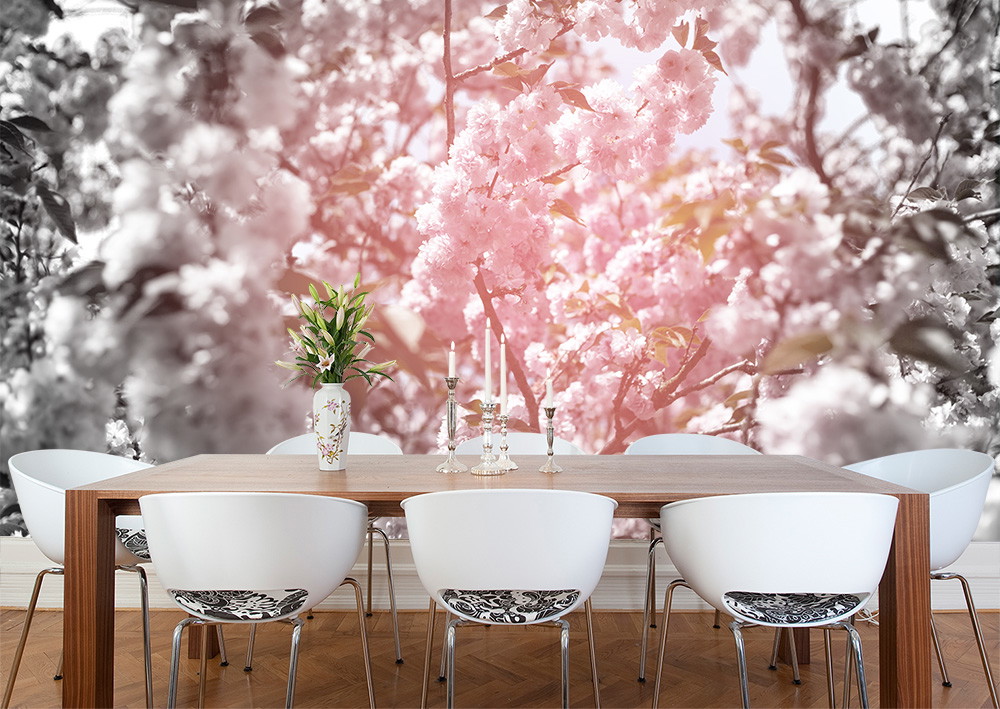 Papier peint photo - salle à manger avec table et chaises devant un grand mur avec des fleurs de cerisier rose pâle en contraste avec un fond noir et blanc