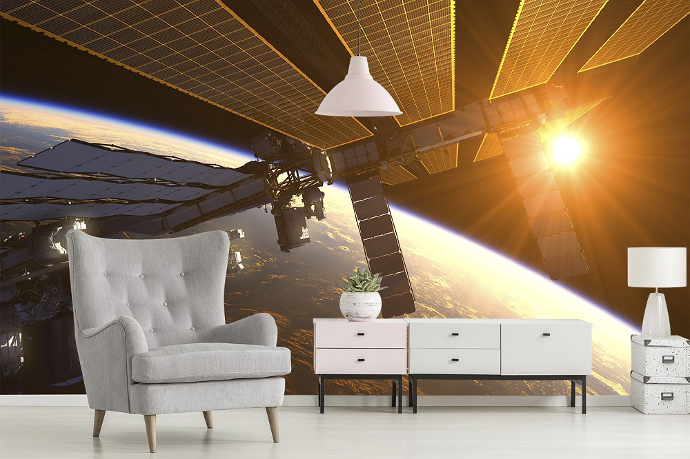 Fototapete - Internationale Raumstation vor der Erde bei Sonnenaufgang, im Wohnzimmer mit grauem Sessel und moderner Kommode