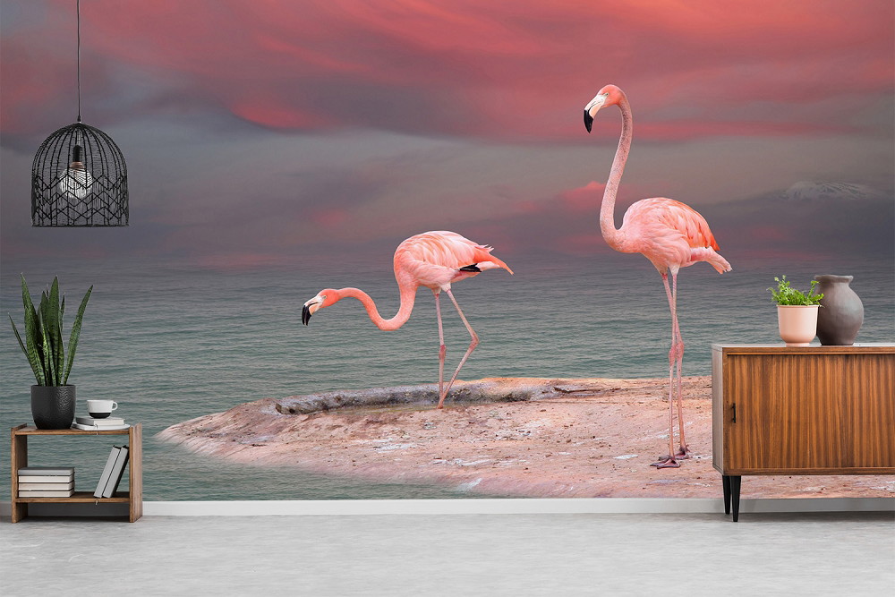 Fototapete - Zwei Flamingos stehen auf einer Felsformation vor einem roten Sonnenuntergang und einem ruhigen Meer.