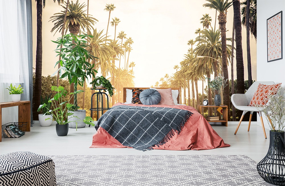 Muurschildering - Gezellige slaapkamer met bed, sierkussen en palmboommotief op de muur