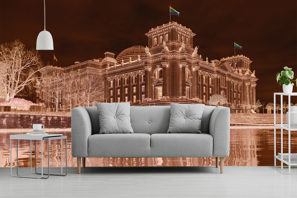Fototapete - Darstellung des Reichstagsgebäudes in kunstvollen Braun- und Kupfertönen bei Nacht, hinter einem stilvollen grauen Sofa