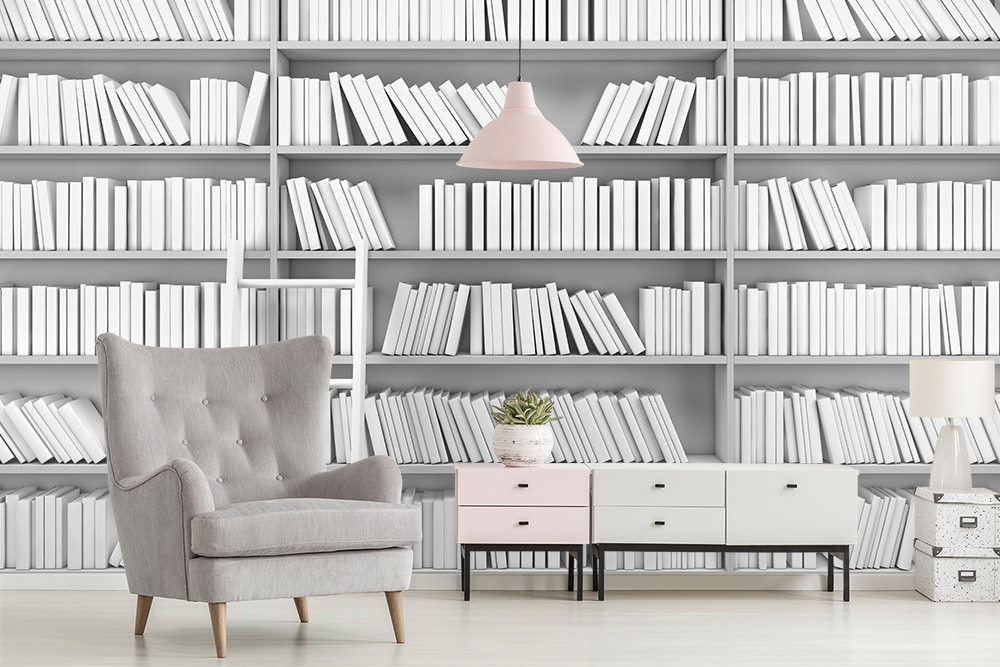 Wall mural - living room with grey armchair, chest of drawers and bookshelf motif on the wall