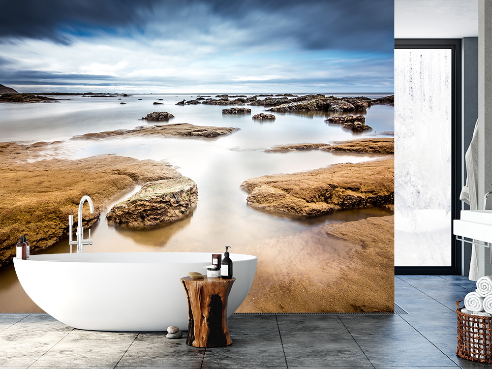 Wall mural - A modern bathroom with a stunning wallpaper that depicts tranquil rocky landscapes by the sea, creating a relaxing atmosphere