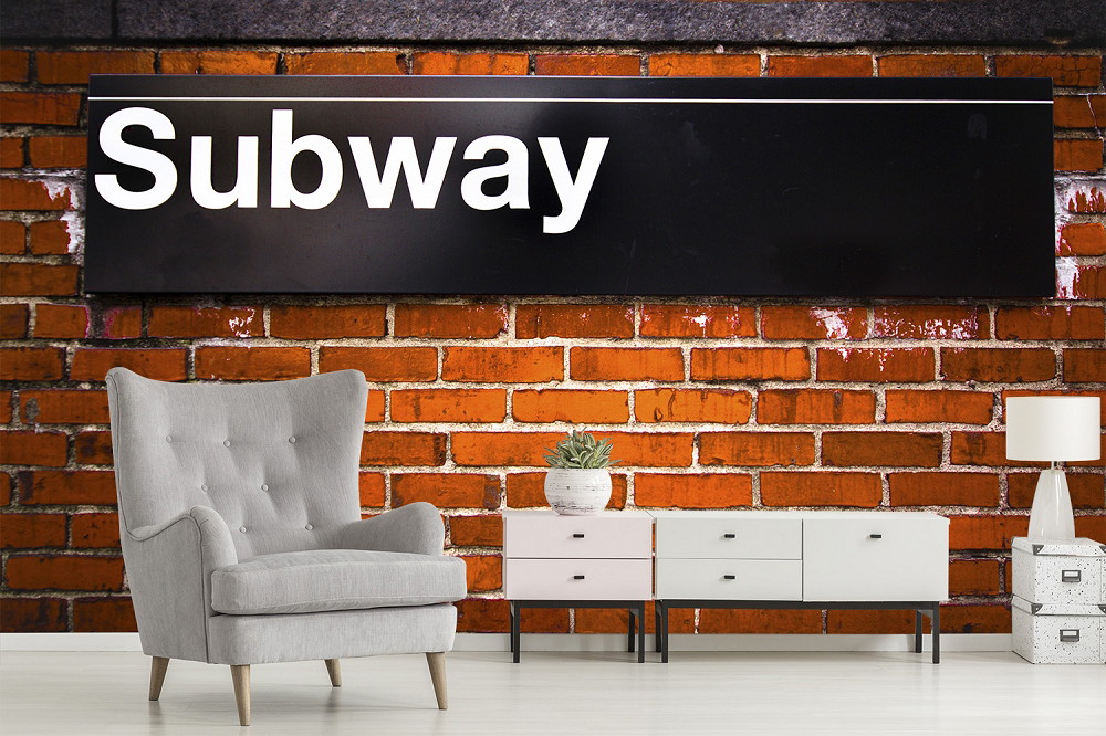 Fototapete - Wohnzimmer mit grauem Sessel, Ziegelwand und Subway-Schild im industriellen Stil