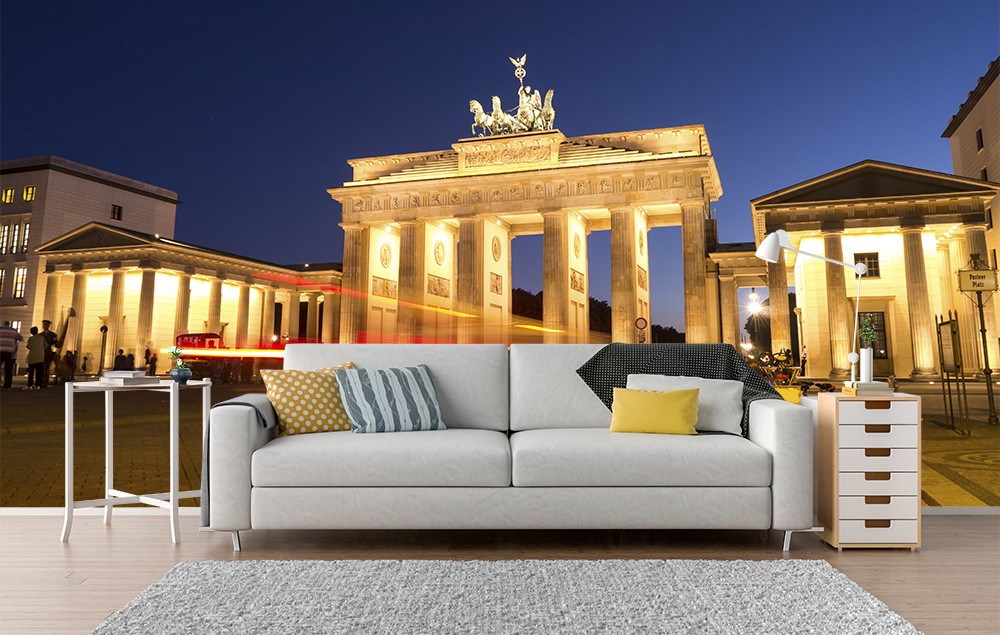 Fotobehang - Gezellige woonkamer met een bank voor de Brandenburger Tor, die ’s nachts helder verlicht is