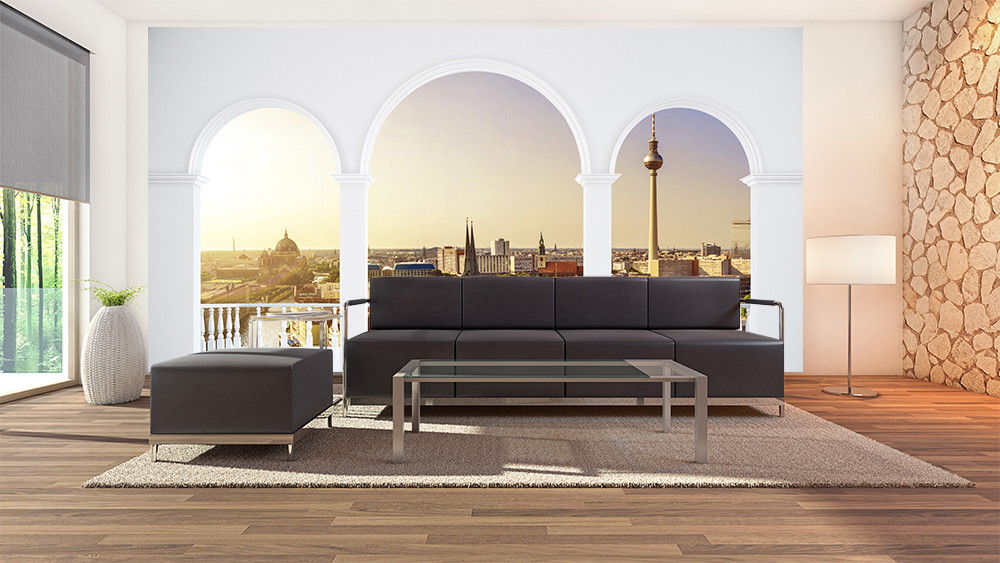 Papier peint photo - salon avec canapé noir et vue sur une silhouette de ville à travers trois arcs blancs