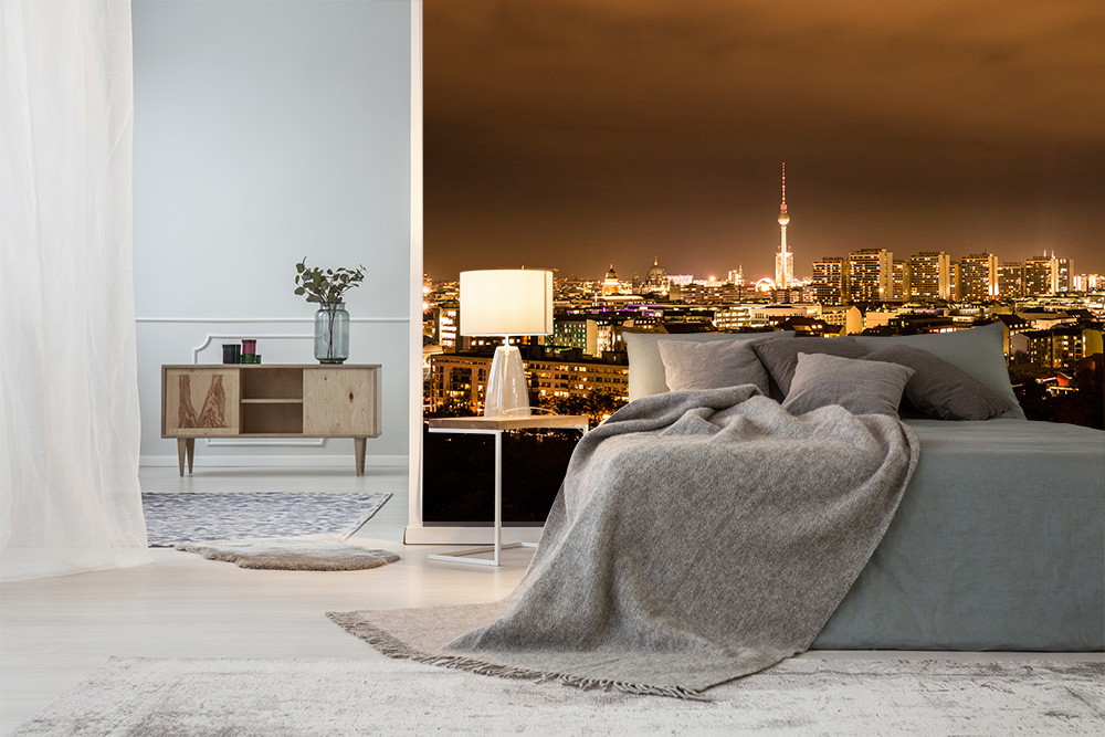 Fototapete - Modern eingerichtetes Schlafzimmer mit Blick auf die beleuchtete Skyline von Berlin bei Nacht