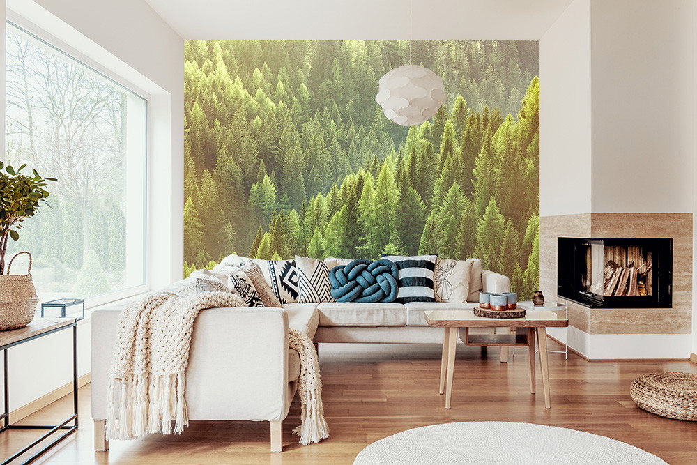 Fototapete - Wohnzimmer mit großer Fensterfront, gemütlichem Sofa und Waldbild an der Wand