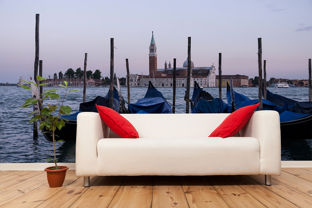 Papier peint photo - salon avec une vue de la ville de Venise, un canapé moderne et des coussins rouges élégants