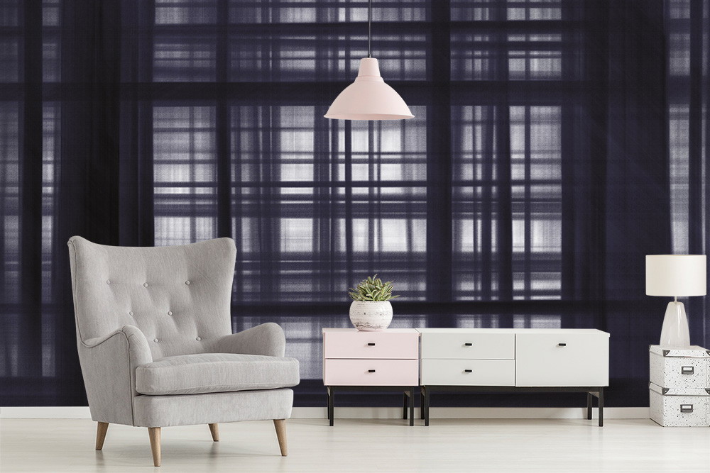Fototapete - Wohnzimmer mit grauem Sessel, hängender Lampe und Kommodenschrank auf einem Hintergrund mit geometrischem Muster in schwarz-weiß.