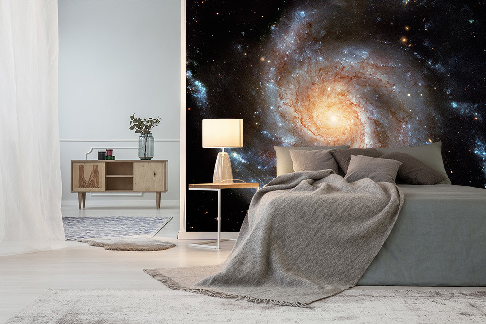 Papier peint photo - chambre à coucher avec une grande galaxie comme décoration murale derrière le lit