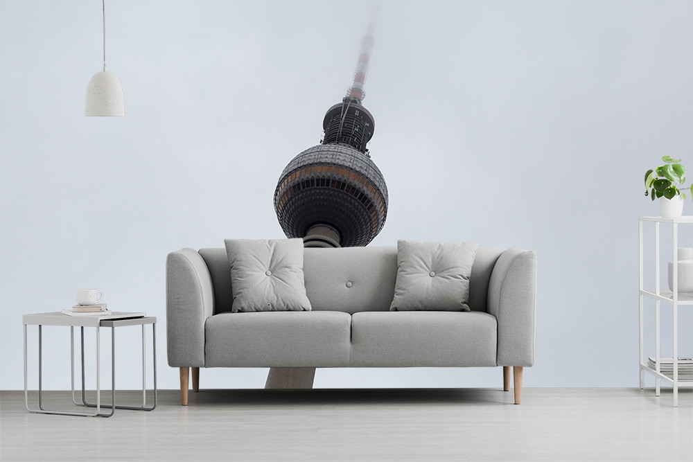Fototapete - Graues Sofa und minimalistisches Interieur vor einer Tapete mit architektonischem Detail im Nebel