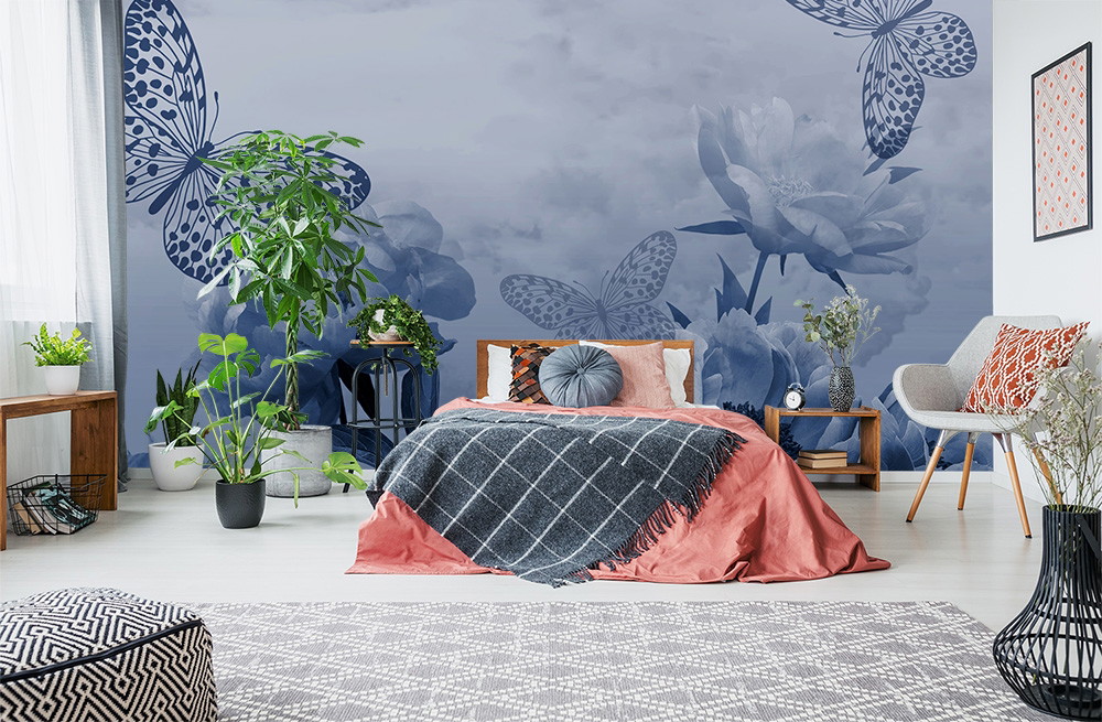 Fototapete - Modernes Schlafzimmer mit großen blauen Schmetterlingen und Blumen an der Wand, umgeben von stilvollen Möbeln und Pflanzen