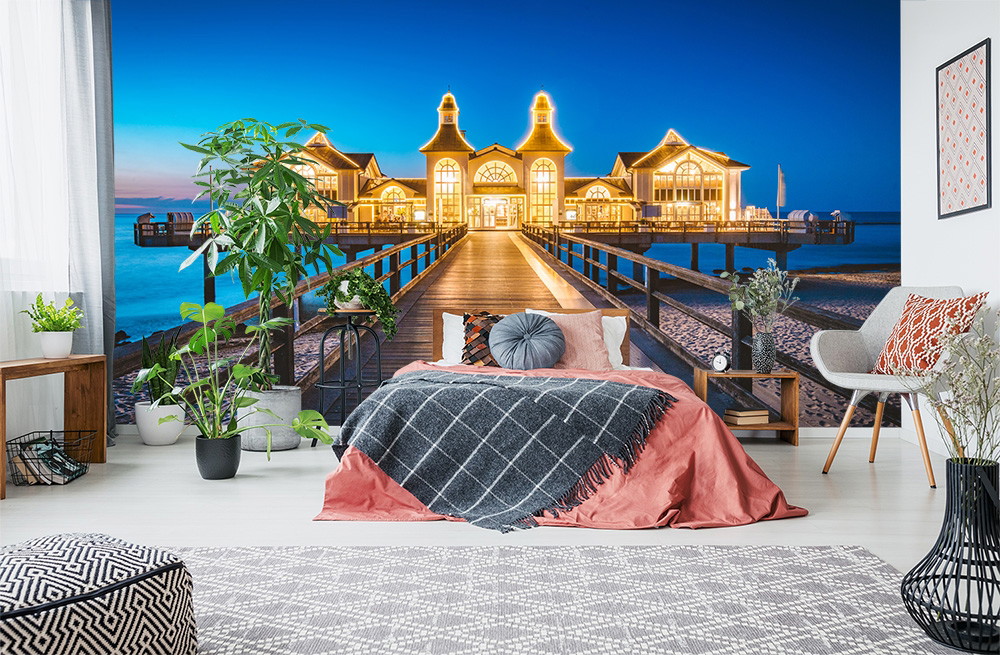 Wall mural - Elegantly furnished bedroom with image of illuminated pier and sea at night