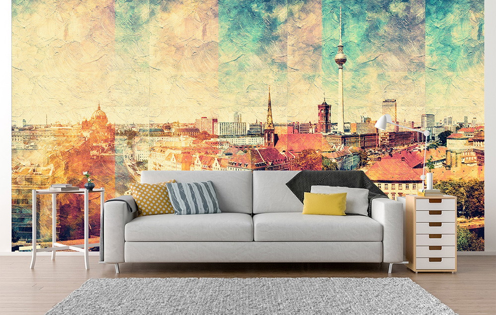Wall mural - living room with sofa set in front of a wall with a watercolour-style cityscape. Contains well-known landmarks of a metropolis that glow in warm colours.