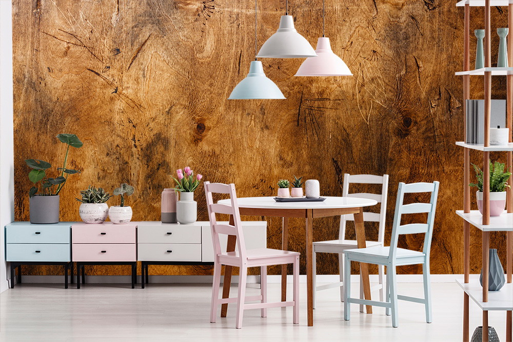 Fototapete - Esszimmer mit Holzwand, Tisch, bunten Stühlen und Pflanzen