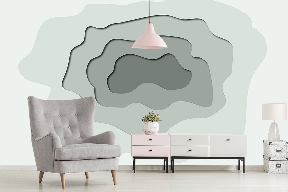 Fototapete - Helles Wohnzimmer mit grauem Sessel, farblich abgestimmter Kommode und dekorativem Pflanzenarrangement vor einer grauen Akzentwand