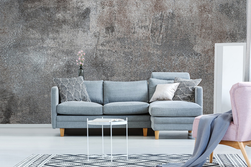 Fototapete - Stilvolles Wohnzimmer mit grauem Sofa, geometrischen Kissen und einer modernen Akzentwand